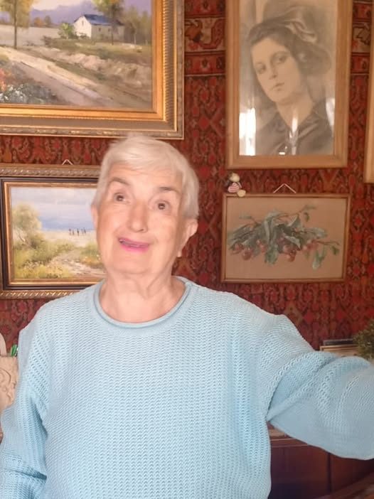 Irina, in front of her paintings — always smiling